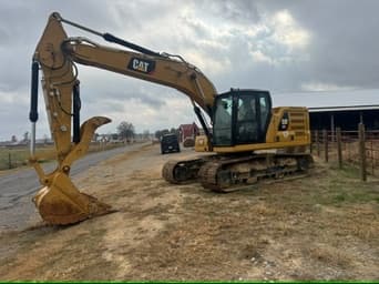 CAT track hoe excavator parked on a roadside gravel area